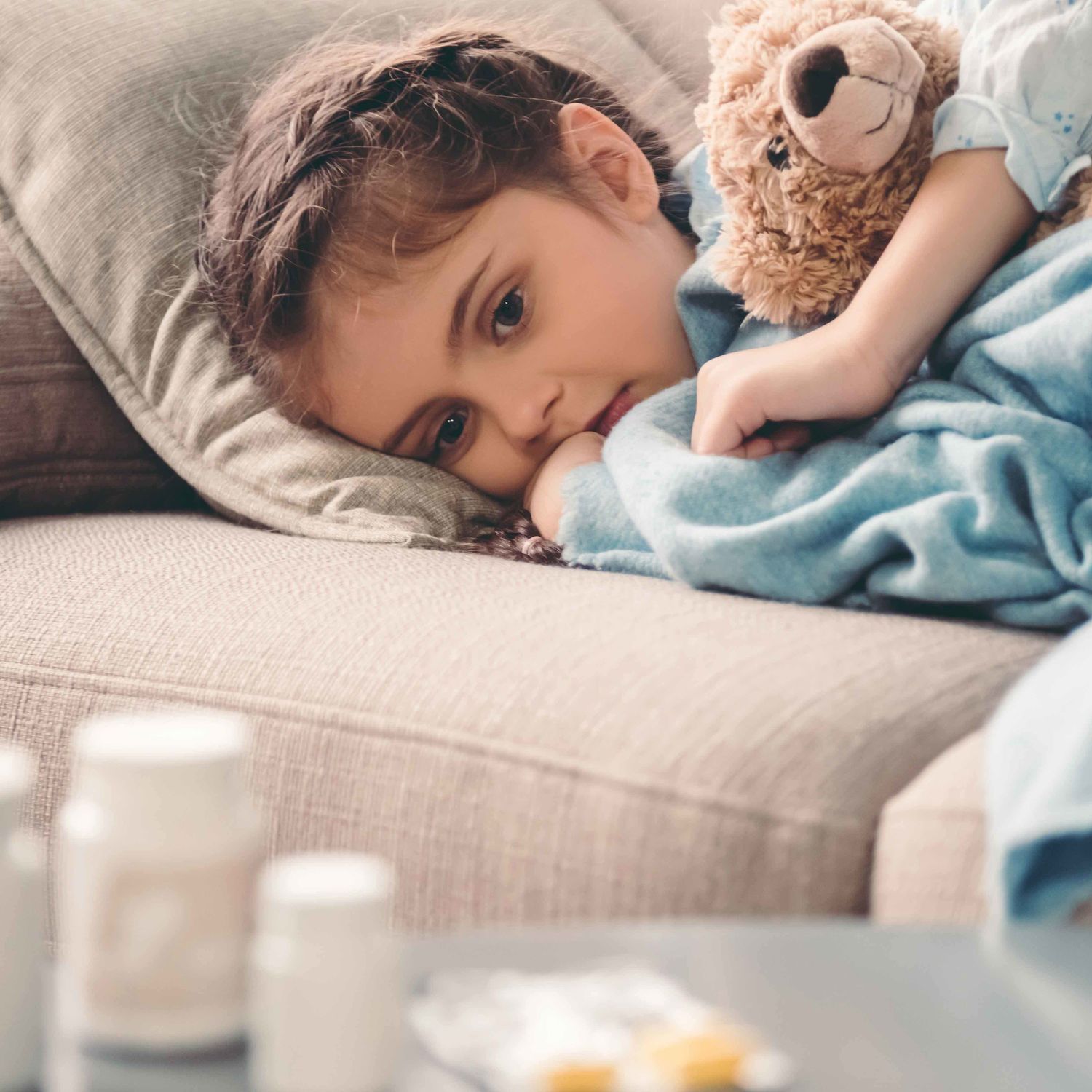 Ein Foto von einem kranken, auf der Couch liegendem Kind.